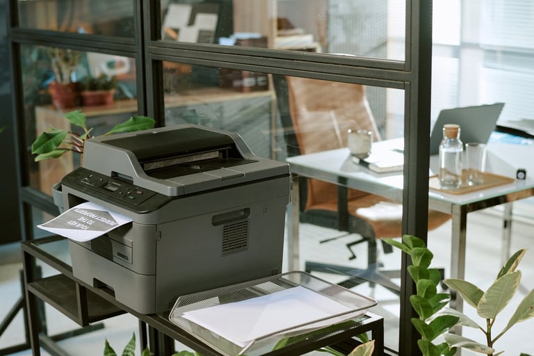 Office printer printing document in modern workspace with glass partitions